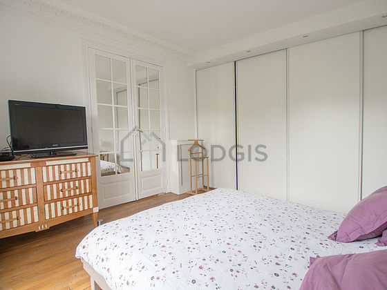 Very bright bedroom equipped with tv, bedside table