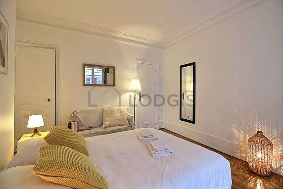 Very bright bedroom equipped with sofa, bedside table
