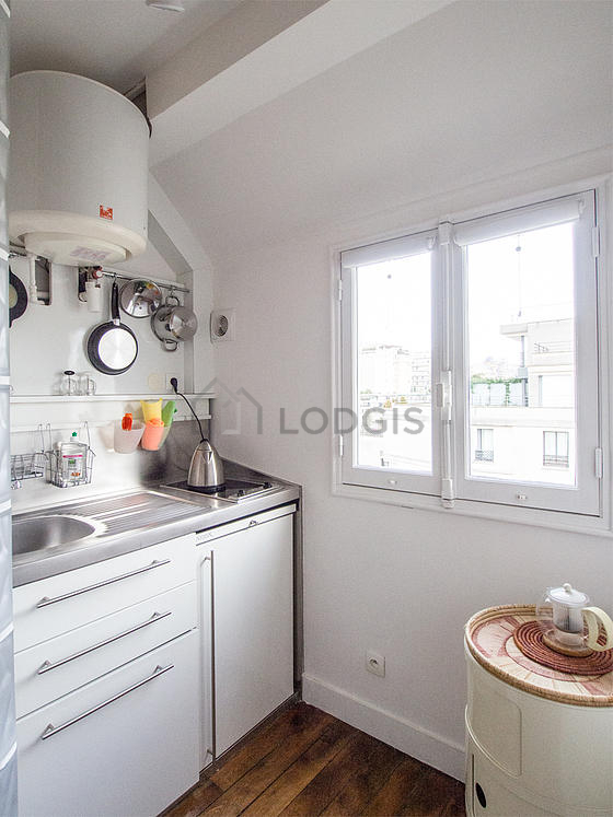 Kitchen equipped with hob, refrigerator, crockery