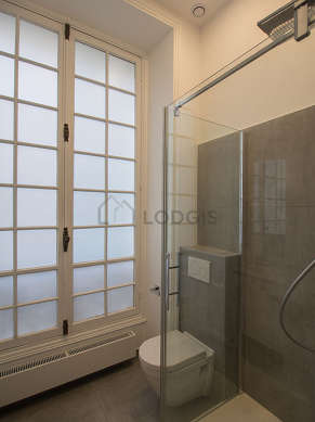 Agréable salle de bain très claire avec fenêtres double vitrage et du carrelageau sol