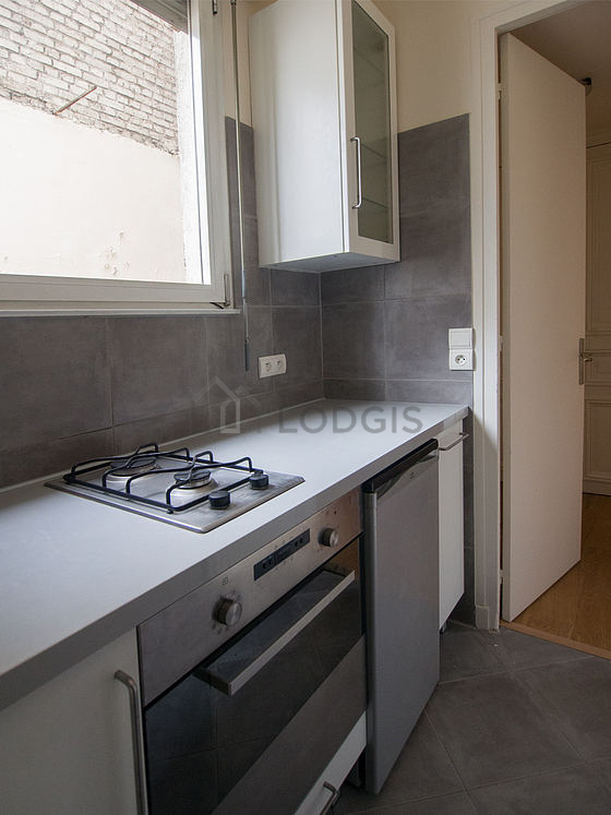 Kitchen equipped with hob, refrigerator, crockery