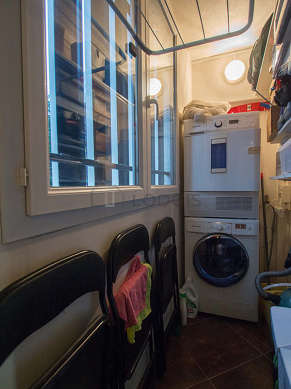 Beautiful laundry room with tilefloor and equipped with washing machine, dryer, 1 chair(s)