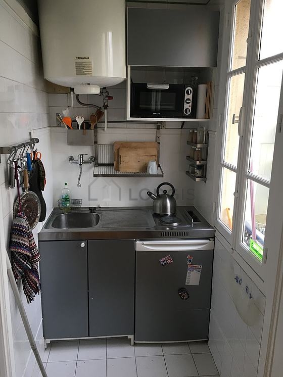 Kitchen equipped with washing machine, refrigerator, stool