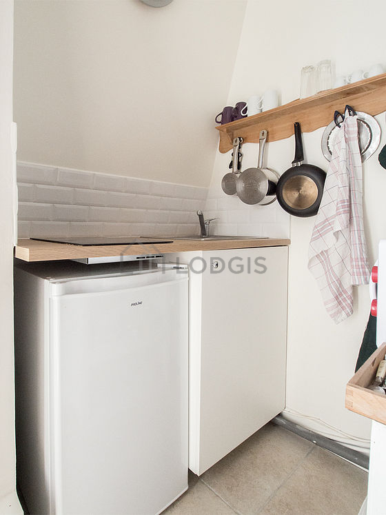 Kitchen equipped with hob, refrigerator, crockery