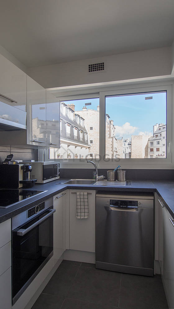 Cuisine équipée de lave vaisselle, plaques de cuisson, réfrigerateur, hotte