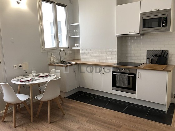 Kitchen equipped with hob, refrigerator, extractor hood, crockery
