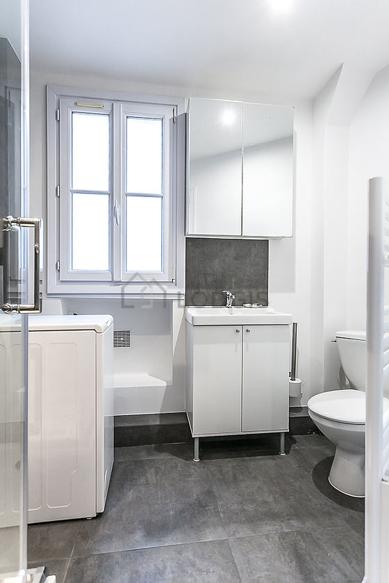 Belle salle de bain claire avec fenêtres et du carrelage au sol