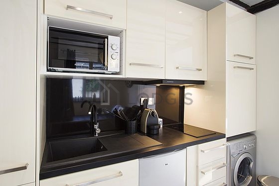 Kitchen equipped with washing machine, refrigerator, extractor hood, crockery