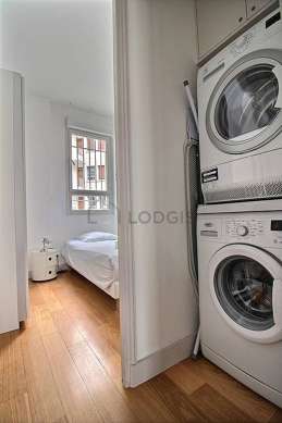 Laundry room with woodenfloor and equipped with washing machine, dryer