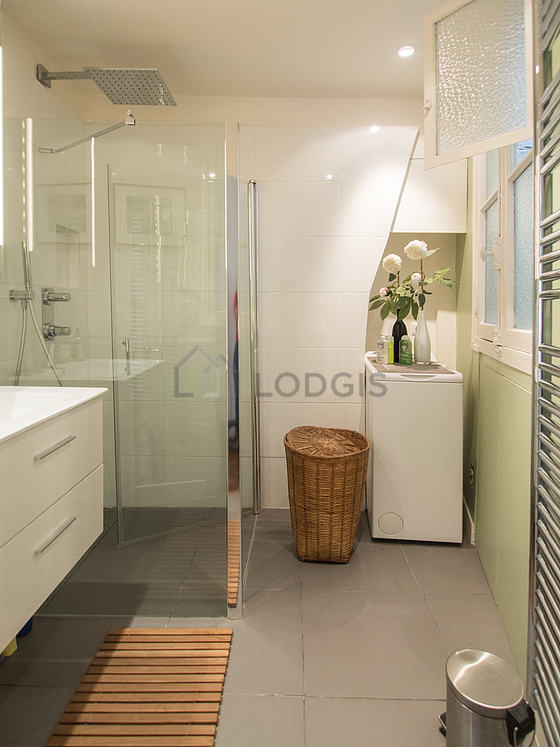 Bathroom equipped with washing machine, separate shower, towel drying radiator