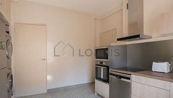 Kitchen equipped with washing machine, dryer, refrigerator, extractor hood