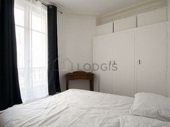 Bright bedroom equipped with wardrobe, cupboard, bedside table