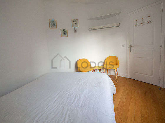 Very bright bedroom equipped with fan, 1 armchair(s), bedside table