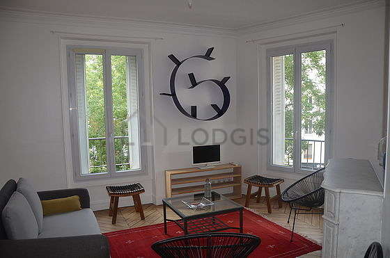 Very quiet living room furnished with tv, fan, 1 armchair(s), 1 chair(s)
