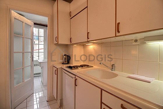 Kitchen equipped with hob, refrigerator, extractor hood, crockery