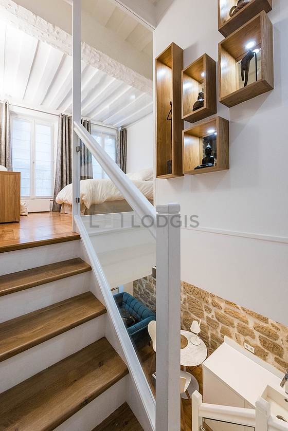 Mezzanine sous belle hauteur de plafond avec du parquet au sol