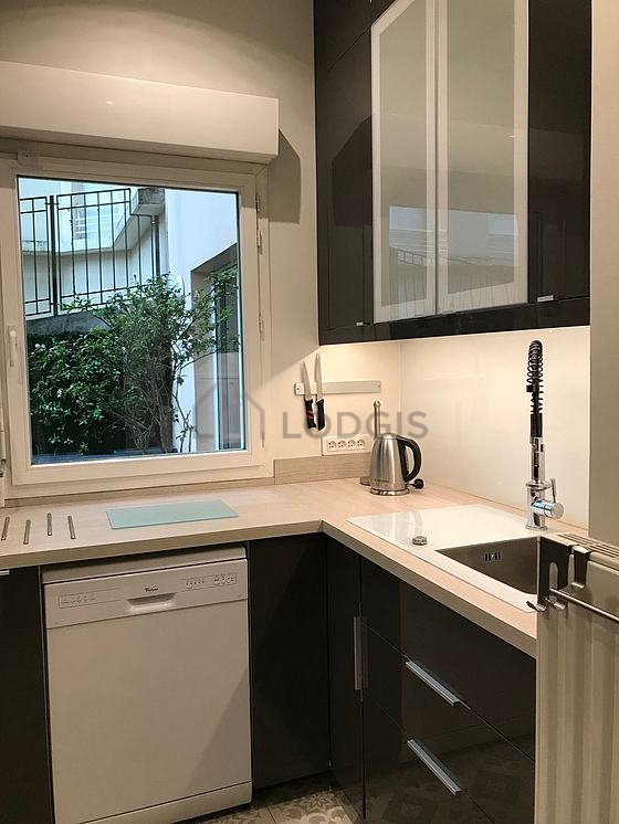 Kitchen equipped with dishwasher, hob, extractor hood, stool