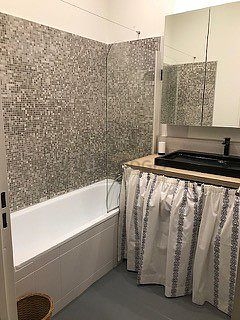 Salle de bain équipée de douche séparée, radiateur sèche-serviettes