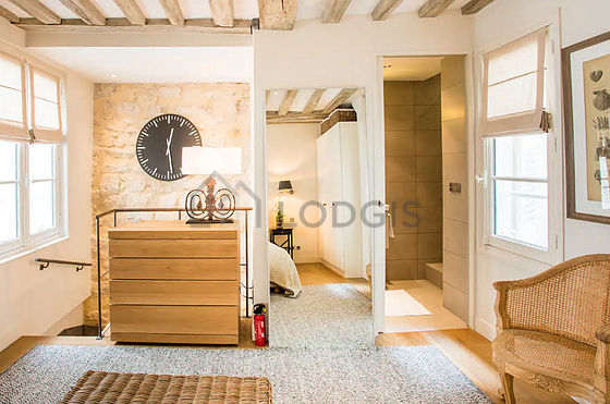 Very bright bedroom equipped with air conditioning, fan, 1 armchair(s), bedside table