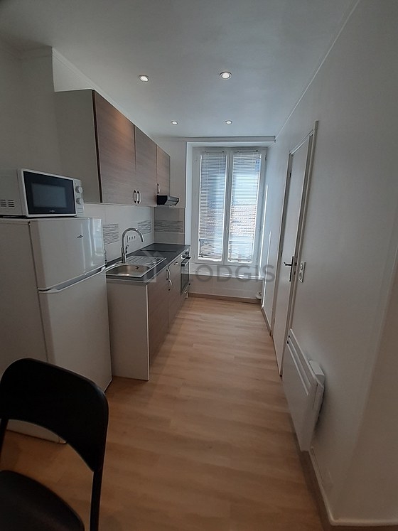Kitchen equipped with hob, refrigerator, extractor hood, crockery