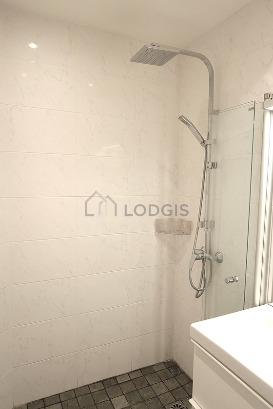 Salle de bain équipée de douche séparée, radiateur sèche-serviettes