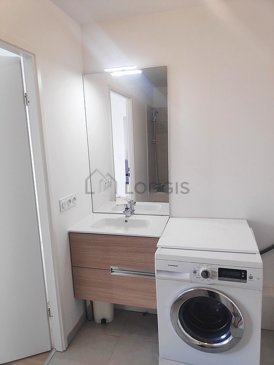 Salle de bain équipée de lave linge, sèche linge, etagère