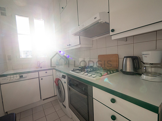 Kitchen equipped with washing machine, refrigerator, extractor hood, crockery