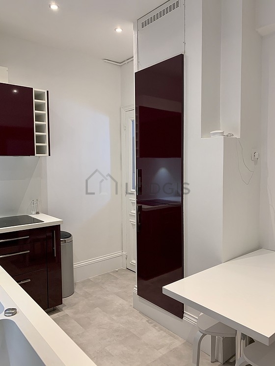 Kitchen equipped with extractor hood, crockery, stool