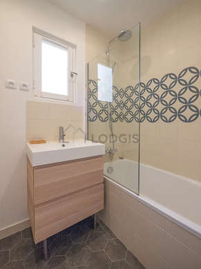 Agréable salle de bain claire avec fenêtres double vitrage et du carrelageau sol