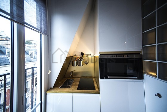 Kitchen equipped with hob, refrigerator, freezer, crockery