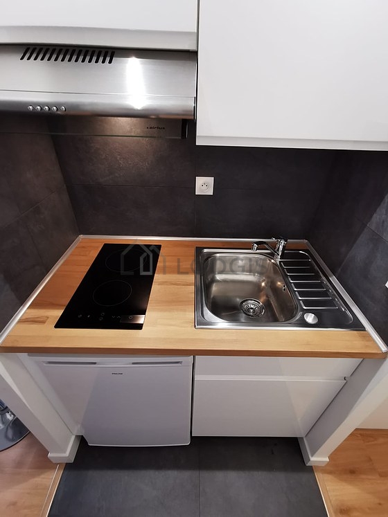 Cuisine équipée de lave vaisselle, plaques de cuisson, réfrigerateur, hotte