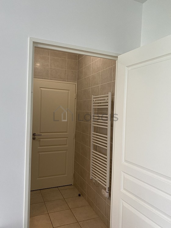 Salle de bain équipée de douche séparée, radiateur sèche-serviettes