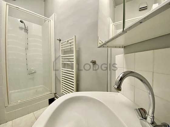 Bathroom equipped with washing machine, separate shower, towel drying radiator
