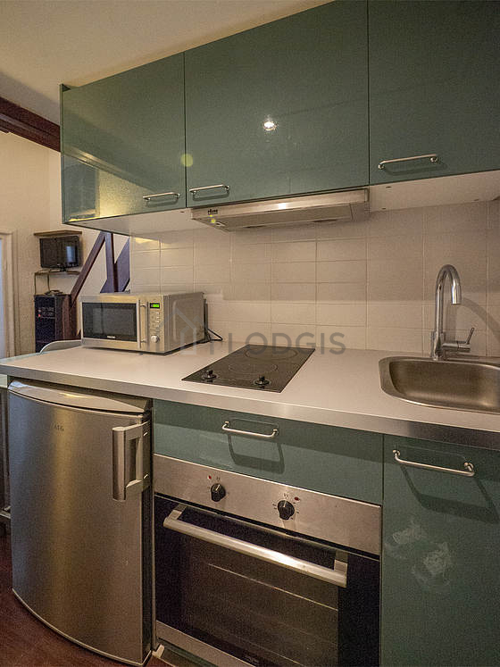Kitchen equipped with hob, refrigerator, extractor hood, crockery