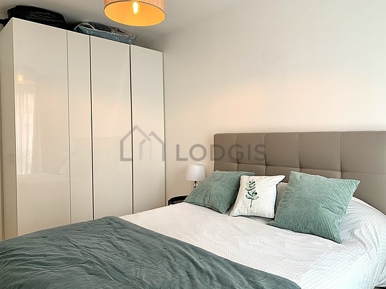 Very bright bedroom equipped with 1 armchair(s), bedside table