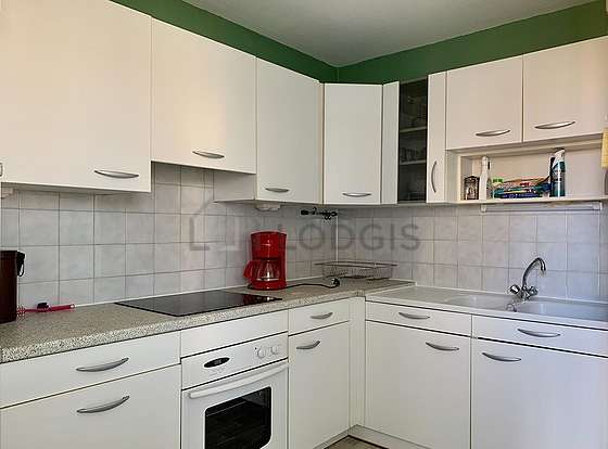 Kitchen equipped with hob, refrigerator, extractor hood, stool