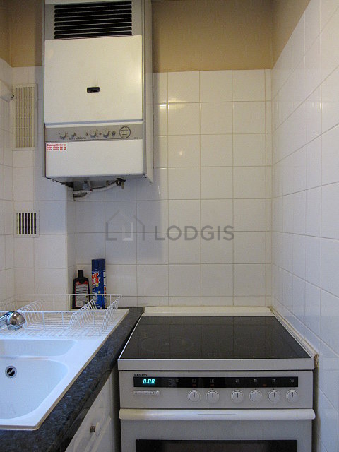 Cuisine équipée de plaques de cuisson, réfrigerateur, vaisselle
