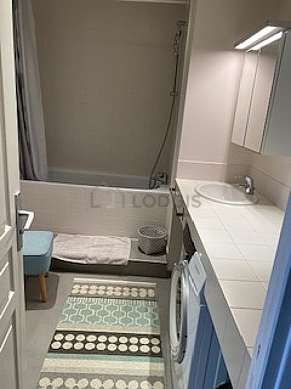 Salle de bain équipée de lave linge, sèche linge, douche dans baignoire