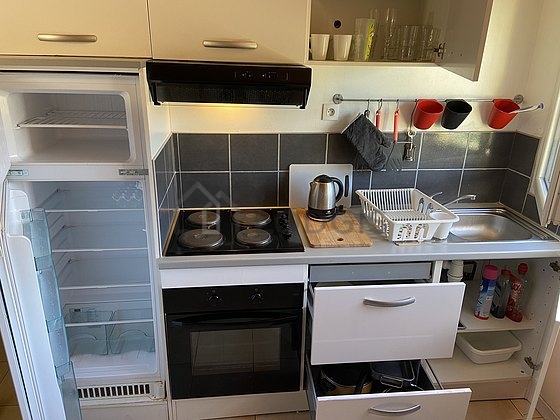 Kitchen equipped with hob, refrigerator, extractor hood, crockery