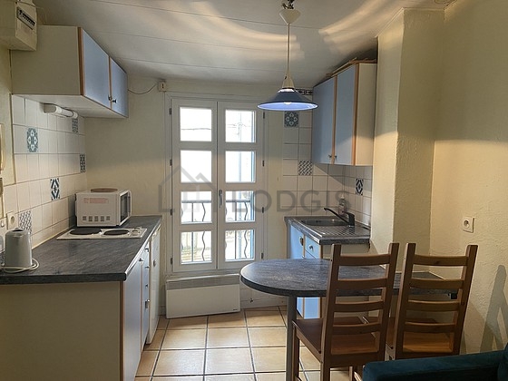 Kitchenopens on the living room with tile floor
