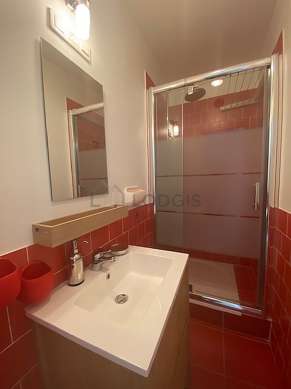 Bathroom equipped with washing machine, separate shower, towel drying radiator