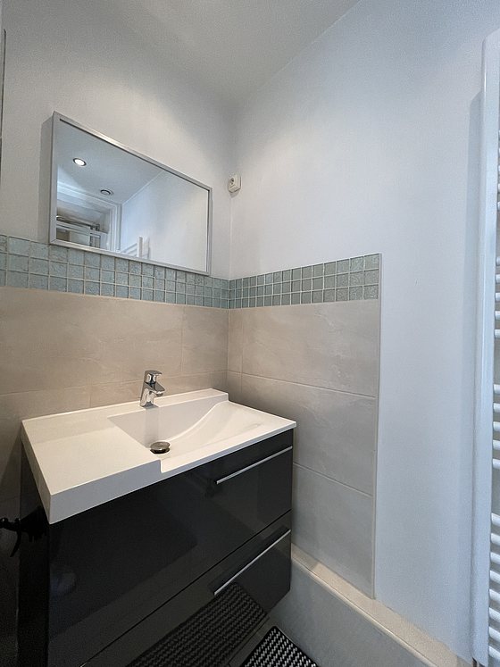 Salle de bain équipée de douche séparée, radiateur sèche-serviettes