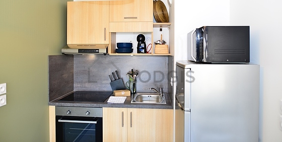 Cuisine équipée de plaques de cuisson, réfrigerateur, hotte, vaisselle