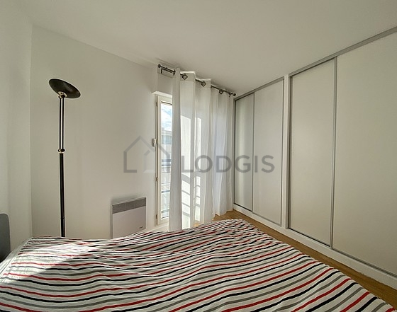 Very bright bedroom equipped with cupboard, bedside table