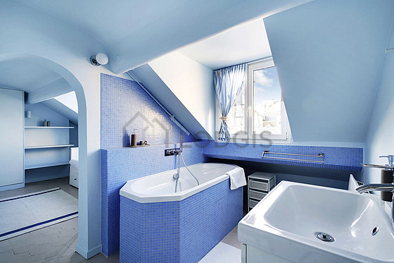 Salle de bain équipée de baignoire, sèche cheveux