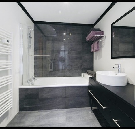Salle de bain équipée de baignoire, radiateur sèche-serviettes