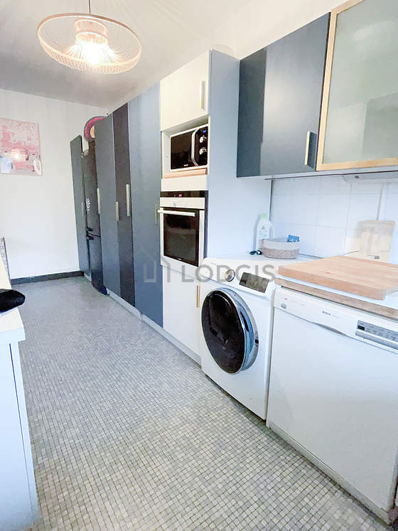 Cuisine équipée de lave linge, sèche linge, réfrigerateur, hotte
