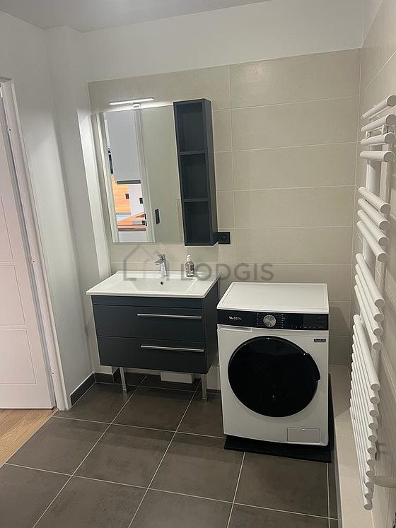 Salle de bain équipée de lave linge, placard