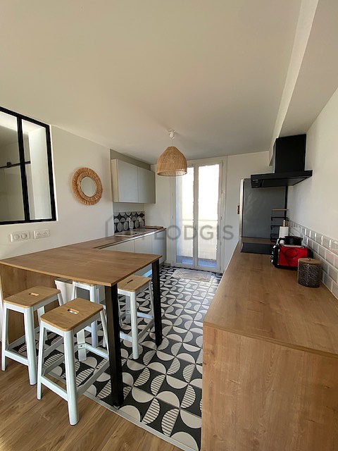 Kitchen equipped with hob, extractor hood, stool