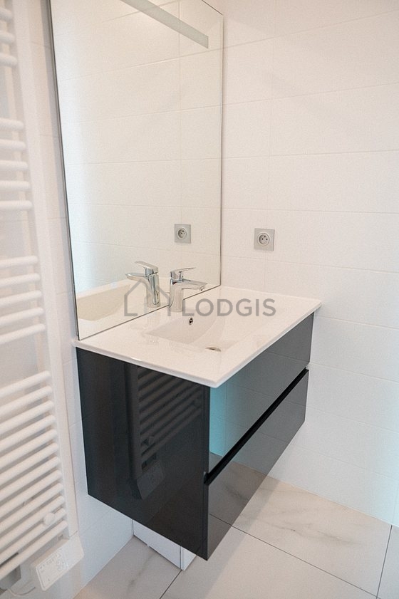 Salle de bain équipée de douche séparée, radiateur sèche-serviettes